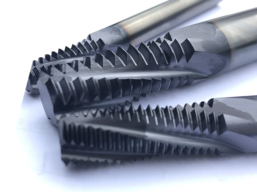Three industrial carbide thread milling cutters with dark, sharp cutting teeth arranged diagonally on a white background.